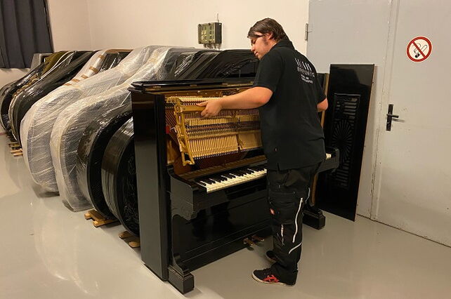 Aaron Breunig entnimmt die Mechanik eines Klaviers.